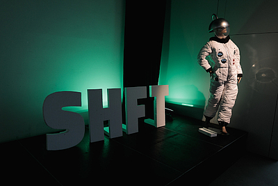 Astronaut und Schriftzug SHFT stehend