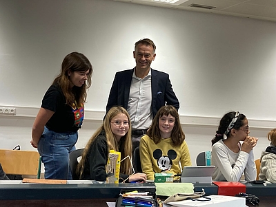 Schüler:innen des BRG Linz Fadingerstraße im Klassenzimmer. Dahinter steht Werner Pamminger (Geschäftsführer Business Upper Austria)