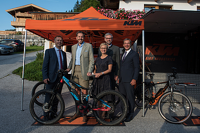 Fünf Personen stehen nebeneinander, gemeinsam mit dem Leih-E-Bikes von KTM. 